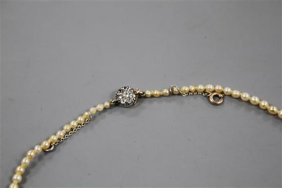 A single strand graduated natural pearl necklace, with old cut diamond cluster set yellow metal clasp.